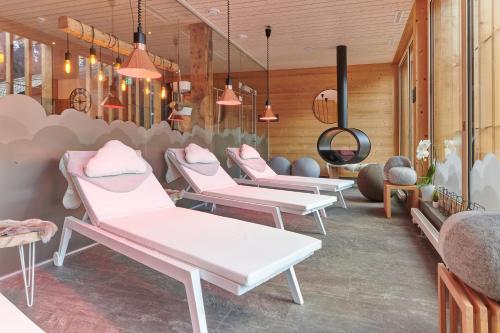 a row of white chairs in a waiting room at Lifestyle Rooms & Suites by Beau-Séjour in Champéry