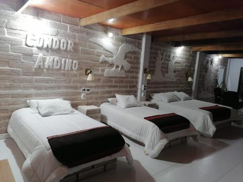 two beds in a room with a brick wall at Casa de Sal - Salt Hotel in Uyuni