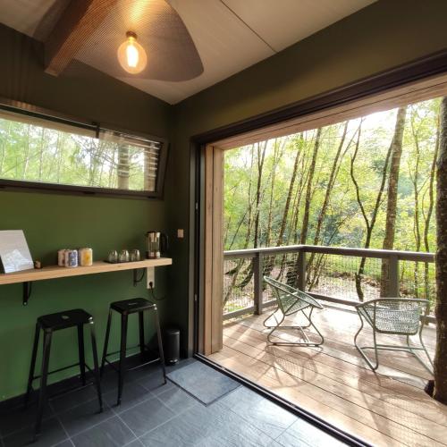 Cette chambre dispose d'une grande porte coulissante en verre et d'une terrasse. dans l'établissement Domaine Spalazen Nature, à Palazinges