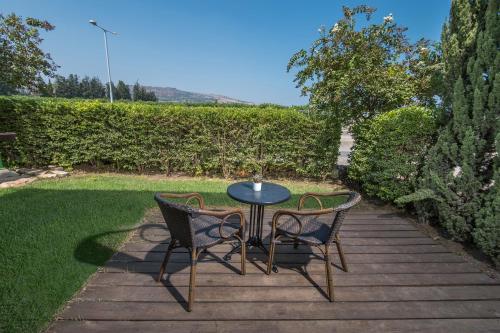 a table and two chairs sitting on a wooden patio at Degania Bet Kibbutz Country Lodging in Kinneret