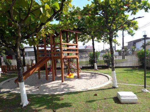 a wooden playground in a park with trees at Brejatuba Residence! Conforto e lazer em excelente condomínio in Guaratuba
