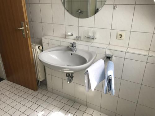 a bathroom with a sink and a mirror and towels at Landgasthof Krone in Lauterach