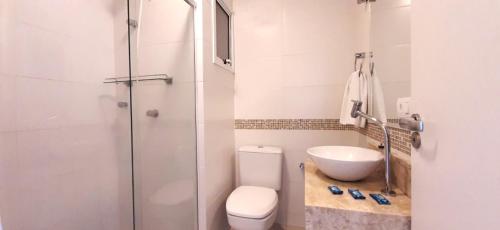 uma casa de banho com um chuveiro, um WC e um lavatório. em Residencial Dona Clara em Pontal do Paraná