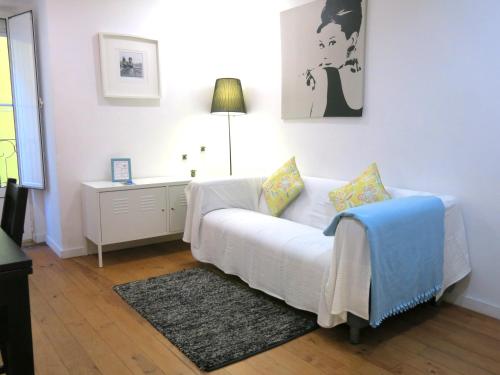 een woonkamer met een witte bank en een tafel bij Wonderful Studio in Lisbon in Lissabon
