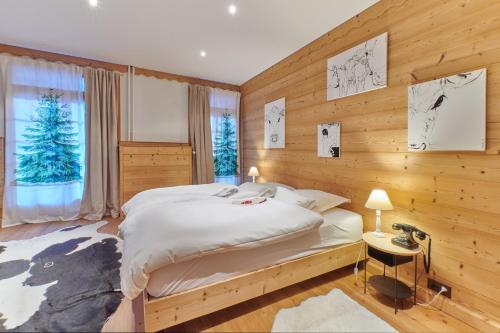 1 dormitorio con 1 cama y pared de madera en Boutique Hotel Beau-Séjour & Spa Superior, en Champéry