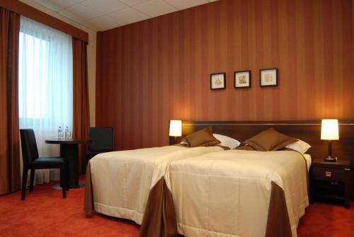 a hotel room with a large bed and a table at Hotel Pik in Mikołów