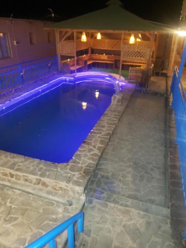 a swimming pool with blue lighting in a backyard at night at Hostal Illauca de Atacama in San Pedro de Atacama
