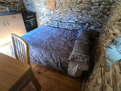 Cama en habitación con pared de piedra en Bordes Pirineu, Costuix, en Àreu