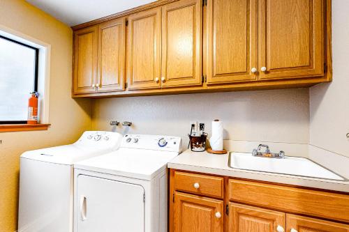 a kitchen with a washer and sink and wooden cabinets at Park Avenue Tahoe Lodge in Homewood