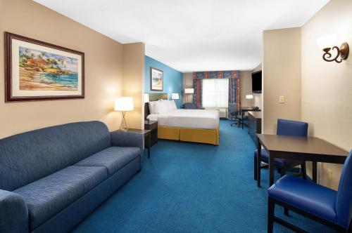 a hotel room with a bed and a couch at Holiday Inn Express & Suites Miami Kendall, an IHG Hotel in Kendall