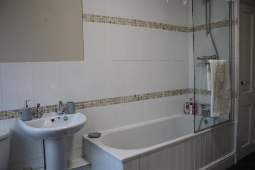 a bathroom with a sink and a bath tub and a sink at Carvetii - Quentin House - Near Hospital, max 7 ppl in Carlisle
