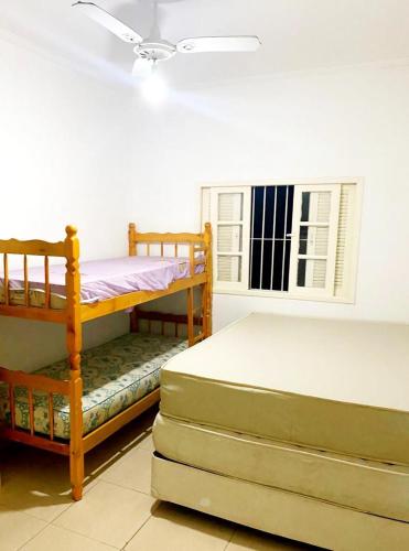 a bedroom with two bunk beds and a window at Peruibe centro mar 944 in Peruíbe