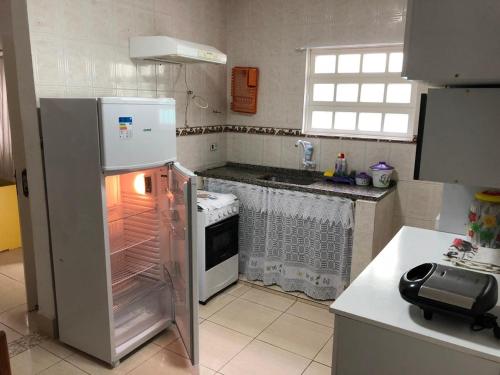 eine Küche mit Kühlschrank und offenem Backofen in der Unterkunft Peruibe centro mar 944 in Peruíbe