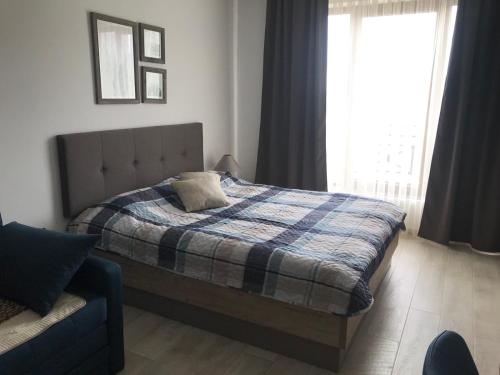 um quarto com uma cama com um cobertor e uma janela em Milmari apartman SAN-28 em Kopaonik
