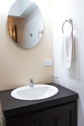 a bathroom with a sink and a mirror at La Fortuna Lodge by Treebu Hotels in Fortuna