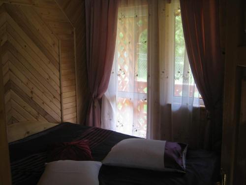 Cama en habitación con ventana en Karpaty Gutsulska Sadyba, en Mykulychyn