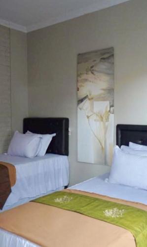 two beds sitting next to each other in a room at Argya Guesthouse in Yogyakarta