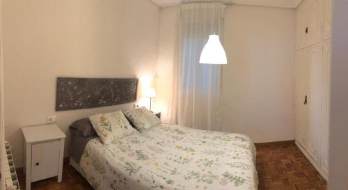 a bedroom with a bed and a lamp and a window at KM0 CENTRO CIUDAD in Valencia