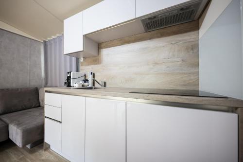uma cozinha com armários brancos e um lavatório em Ms Estrada Mobile Homes em Biograd na Moru