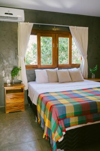 a bedroom with a bed with a colorful blanket at La Casina Jericoacoara in Jericoacoara