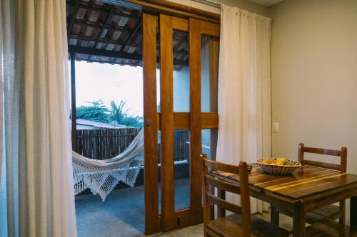 a dining room with a wooden table and a window at La Casina Jericoacoara in Jericoacoara