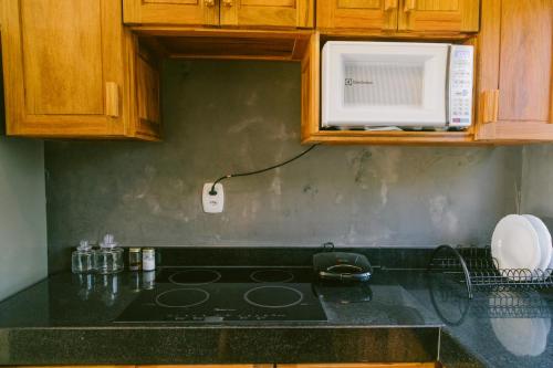 a kitchen with a stove and a microwave at La Casina Jericoacoara in Jericoacoara