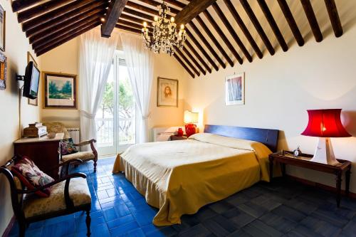a bedroom with a bed and a chandelier at Villa Sole di Capri - Vista Mare in Massa Lubrense
