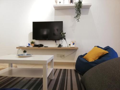 a living room with a tv and a couch and a table at Subang City Residence, 8-9 pax with Balcony, Walking Distance to Summit, 5min to Sunway in Subang Jaya