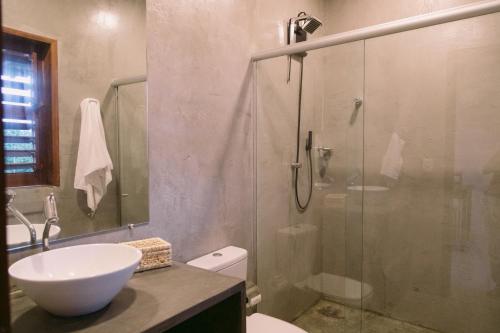 a bathroom with a shower and a sink and a toilet at La Casina Jericoacoara in Jericoacoara