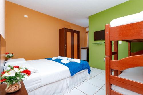 a bedroom with a bed and a bunk bed at Pousada Iguana in Canoa Quebrada
