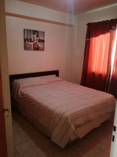 1 dormitorio con 1 cama con cortina roja en Tini en Neuquén