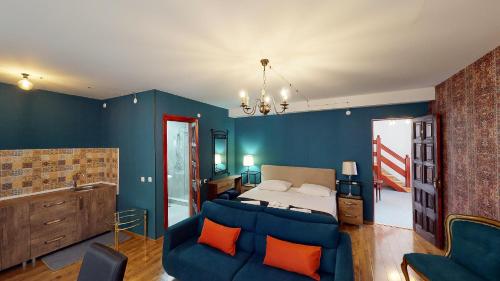 a bedroom with blue walls and a bed with orange pillows at Boutique Hotel Shale in Bakuriani