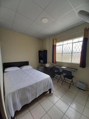 a bedroom with a bed and a desk in it at Kira's House in Piura