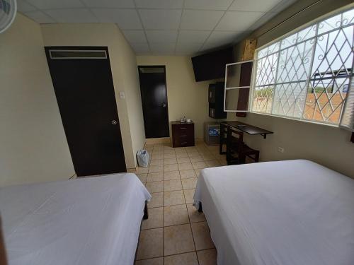 a room with two beds and a window at Kira's House in Piura