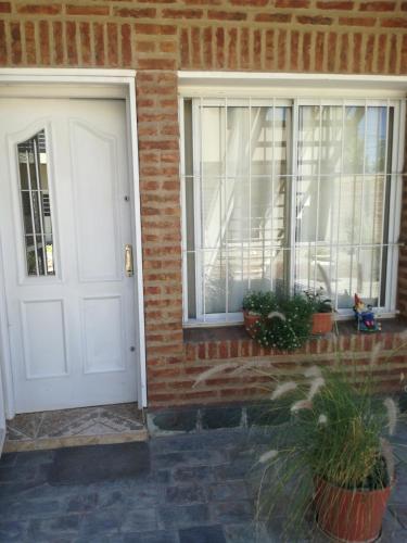 a white door and windows on a brick house at Tini in Neuquén
