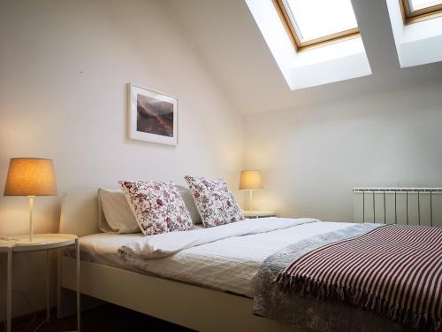 um quarto branco com uma cama com almofadas e janelas em FilinHome Dusana 3-bedroom Suite em Novi Sad