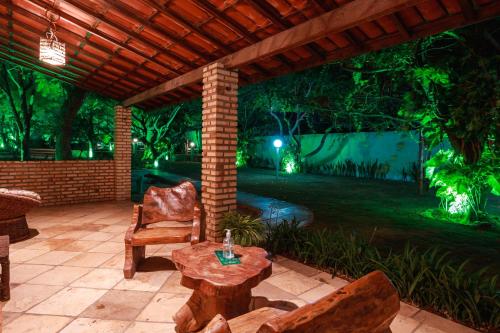 a patio with a table and chairs at night at Pousada Iguana in Canoa Quebrada