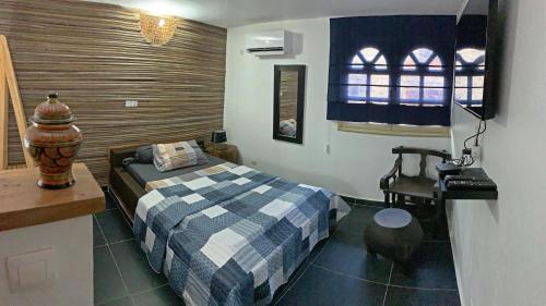 a bedroom with a bed and a desk and a chair at Hotel Blawa in Abidjan