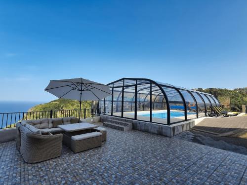 a patio with a swimming pool and a glass house at Casa Leão de Ouro by LovelyStay in São Jorge