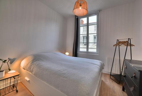 a bedroom with a bed and a window at Superbe T2 de 45m² en hyper centre in La Rochelle