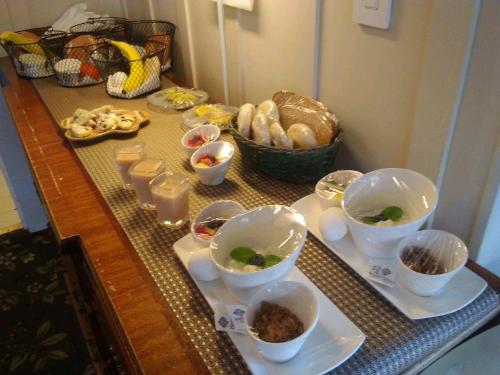 einen Tisch mit Schalen mit Lebensmitteln und anderen Lebensmitteln in der Unterkunft Carmel Green Lantern Inn in Carmel