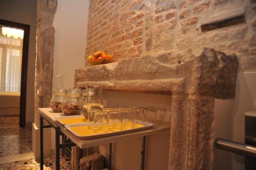 a table with glasses on it with a stone wall at 3C B&B in Venice