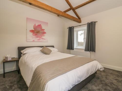 Un dormitorio con una cama grande y una ventana en Ploughman's Rigg en Harrogate