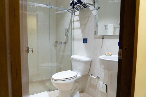 een badkamer met een douche, een toilet en een wastafel bij Sea Colors Hotel in San Andrés