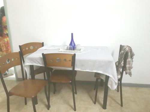 a dining room table with a white table cloth and chairs at Comfortable House in Trou d'Eau Douce in Trou dʼ Eau Douce