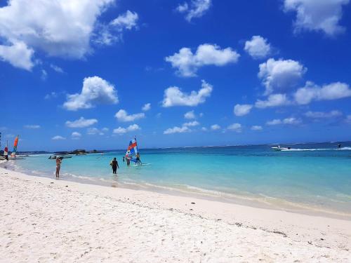 a group of people on a beach in the ocean at Comfortable House in Trou d'Eau Douce in Trou dʼ Eau Douce
