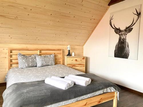 Osada Koniaków 3 في كونيكاو: غرفة نوم مع سرير مع صورة غزلان على الحائط