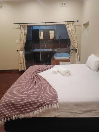 een slaapkamer met een groot wit bed en een raam bij 180 On Anderson Guest House in Pretoria