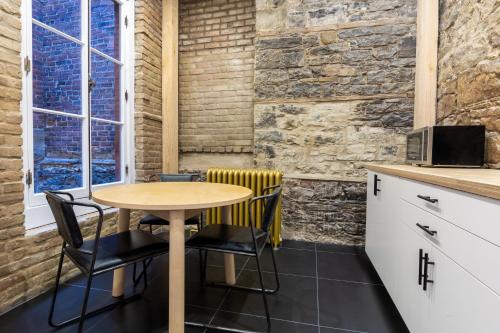 a table and chairs in a kitchen with a brick wall at Le Haute Ville in Quebec City