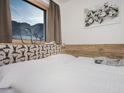 a bedroom with a white bed with a window at LENZup Apartments in Mayrhofen